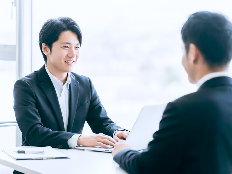 デスクで打ち合わせを行う営業担当者