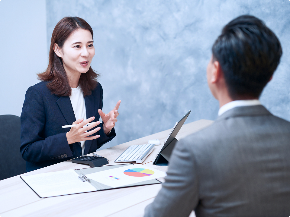 データを示しながらお客様と向き合って話す担当者